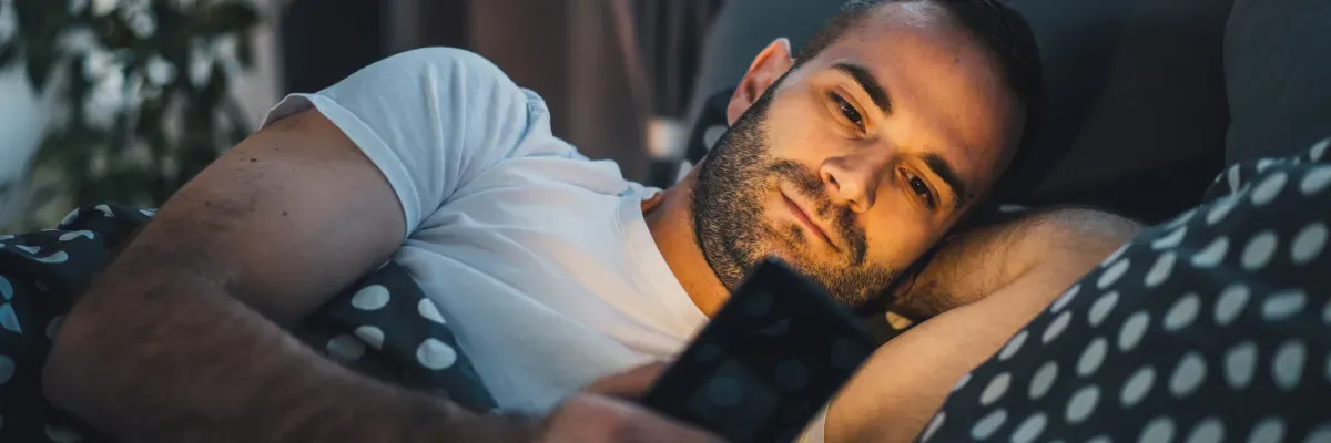man-using-phone-in-bed
